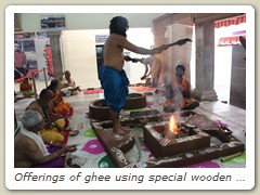 Offerings of ghee using special wooden spoons
